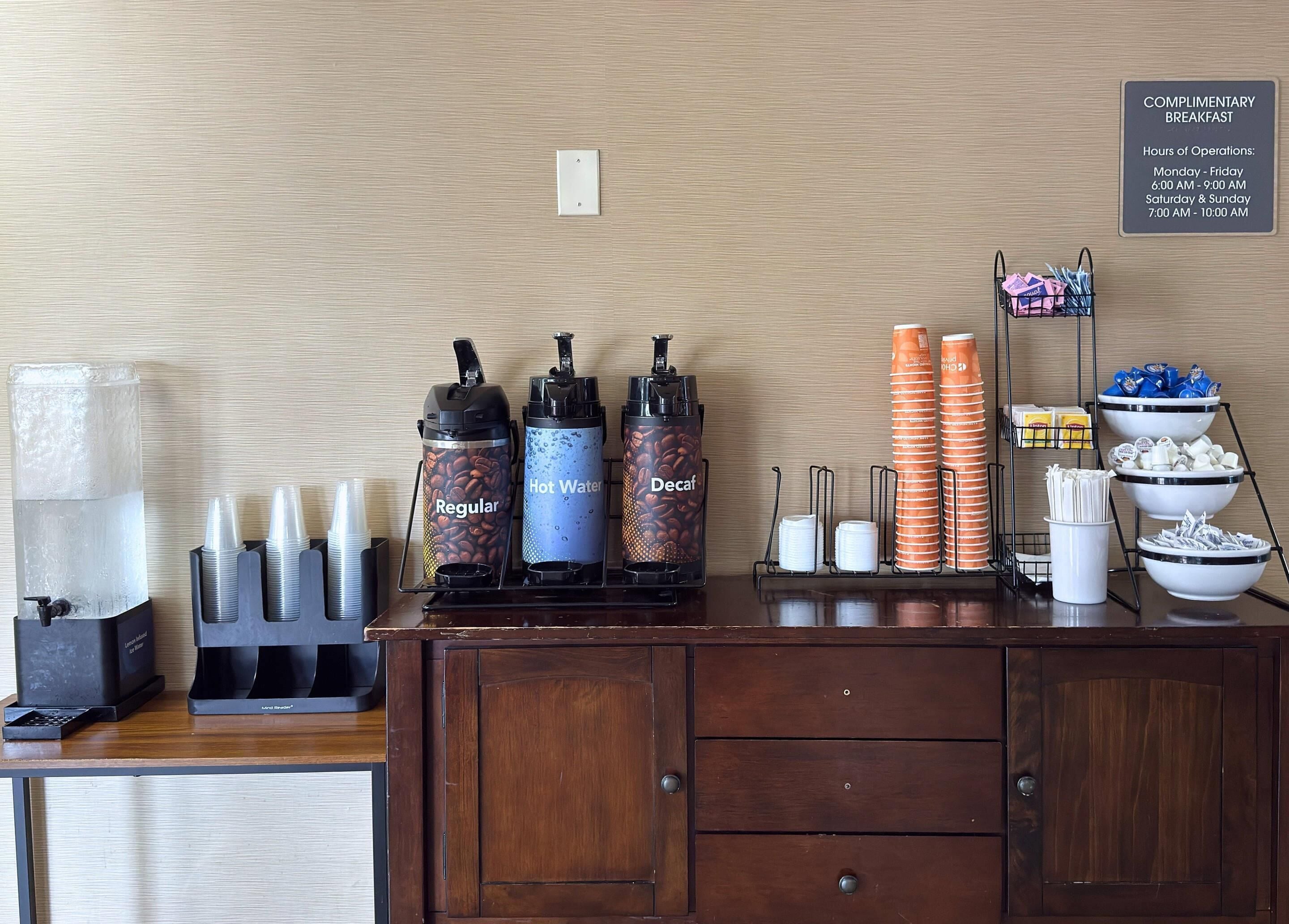 Un espace dédié au petit-déjeuner, équipé de distributeurs de café, d’un point d’eau chaude et d’une sélection de cafés décaféinés, ainsi que de gobelets en papier, de serviettes et de condiments.