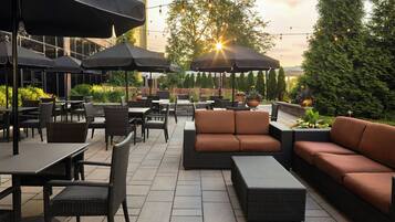 An outdoor seating area with tables, chairs, and umbrellas.