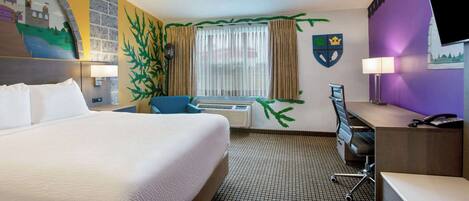A hotel room with a bed, desk, chair, and a television.