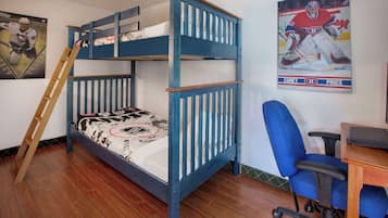 Cozy retreat with a hockey-themed bunk bed, desk, and office chair, perfect for a fun stay.