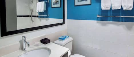 Un baño con un lavamanos blanco, un espejo, un inodoro y paredes azules.