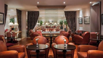 Un amplio salón con asientos de cuero, chimenea central y una mesa de comedor.