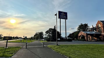 A hotel entrance with a clear sky and a sunset.
