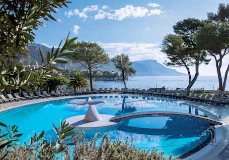 Seasonal outdoor pool, pool umbrellas, sun loungers. Hôtel Vacances Bleues Delcloy