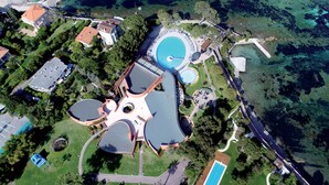 An aerial view of a resort with a large circular pool, a central building with a dome, and surrounding greenery. - Hôtel Vacances Bleues Delcloy (Saint-Jean-Cap-Ferrat)