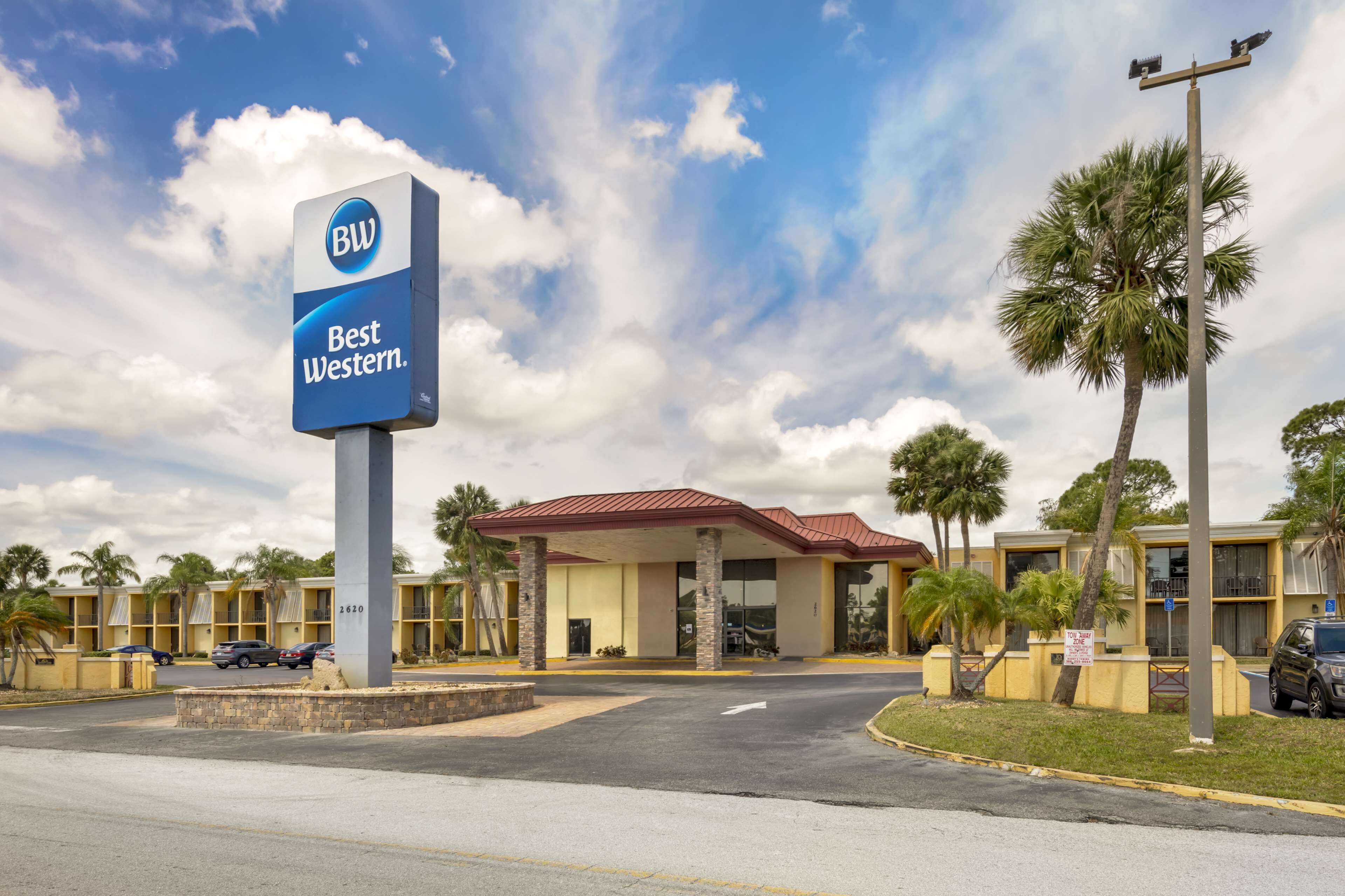 Un hotel con un llamativo letrero de 'BW Best Western', que presenta un techo rojo y un diseño moderno.
