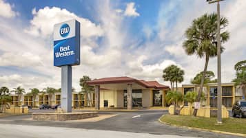 A hotel with a prominent 'BW Best Western' sign, featuring a red roof and a modern design.
