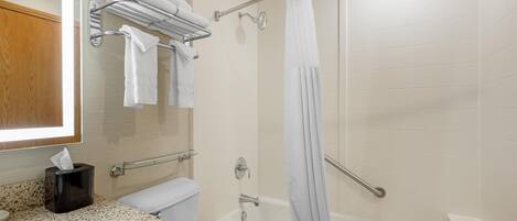 A bathroom with a toilet, sink, bathtub, and shower curtain.