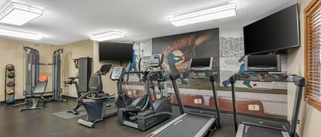 A gym with treadmills, elliptical machines, and weightlifting equipment.