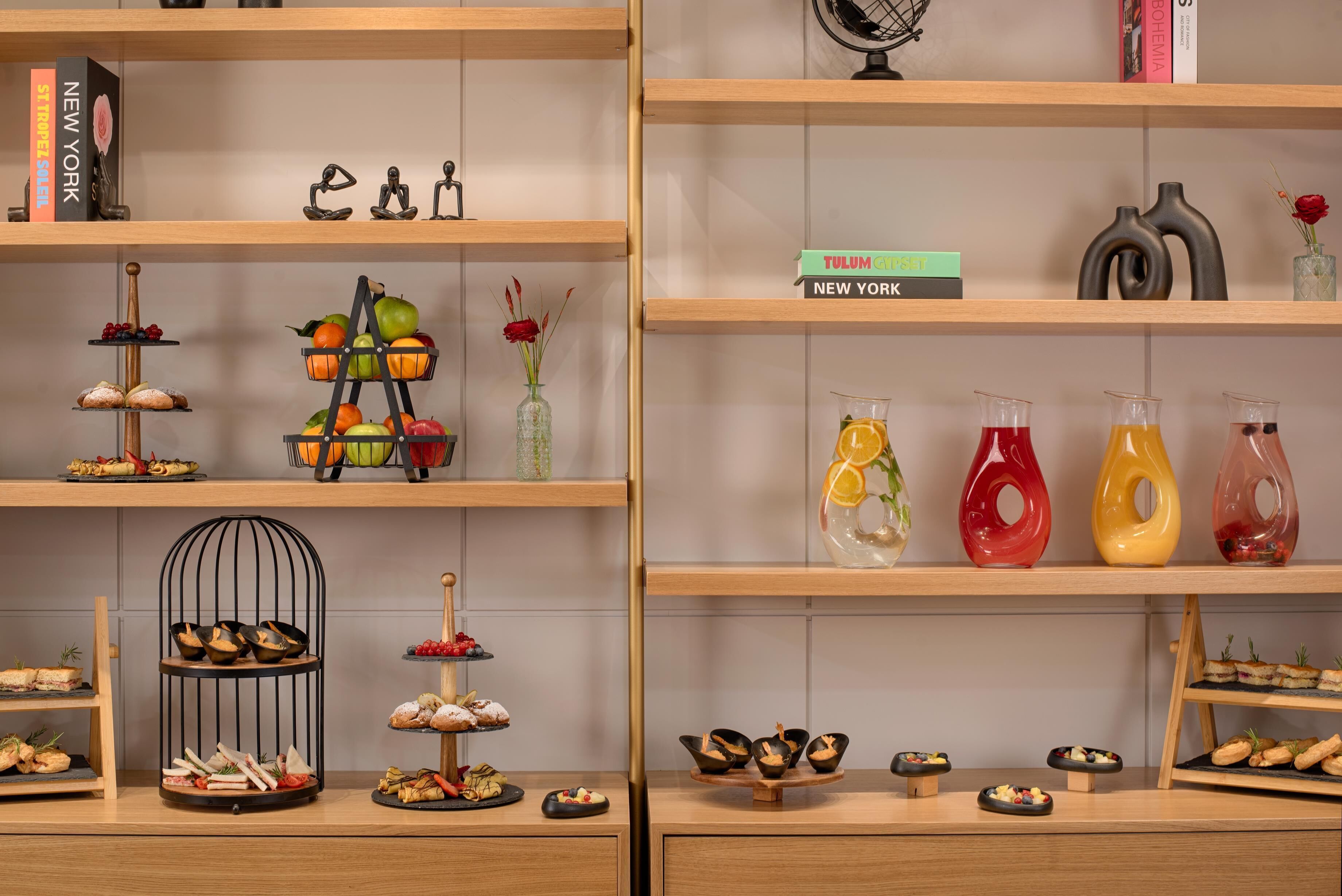 A display of food items on shelves, including fruits, pastries, and drinks.