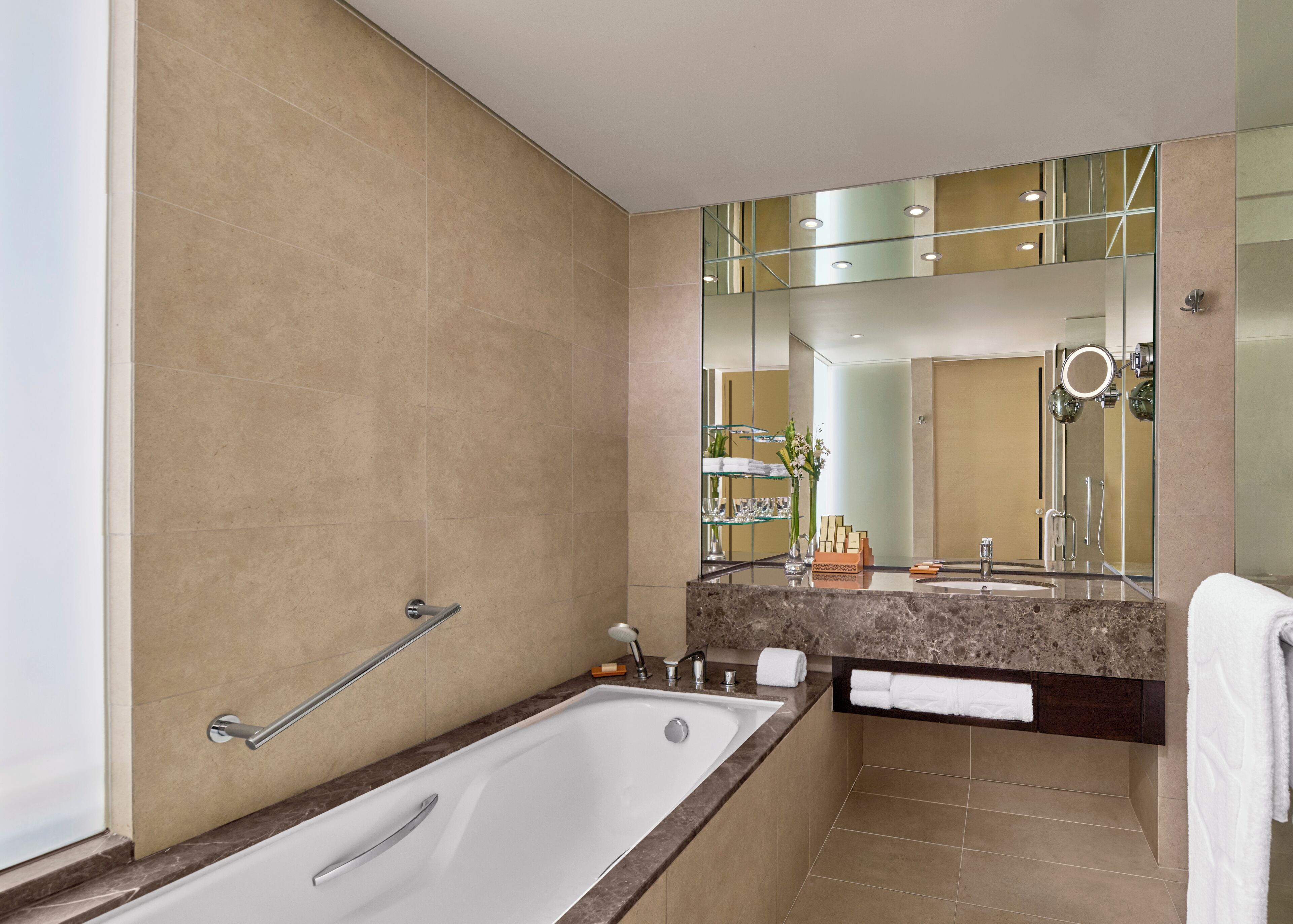 Un bagno moderno con vasca, un mobile vanitario con specchio e zona doccia.