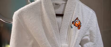 A white robe hanging on a wooden hanger.