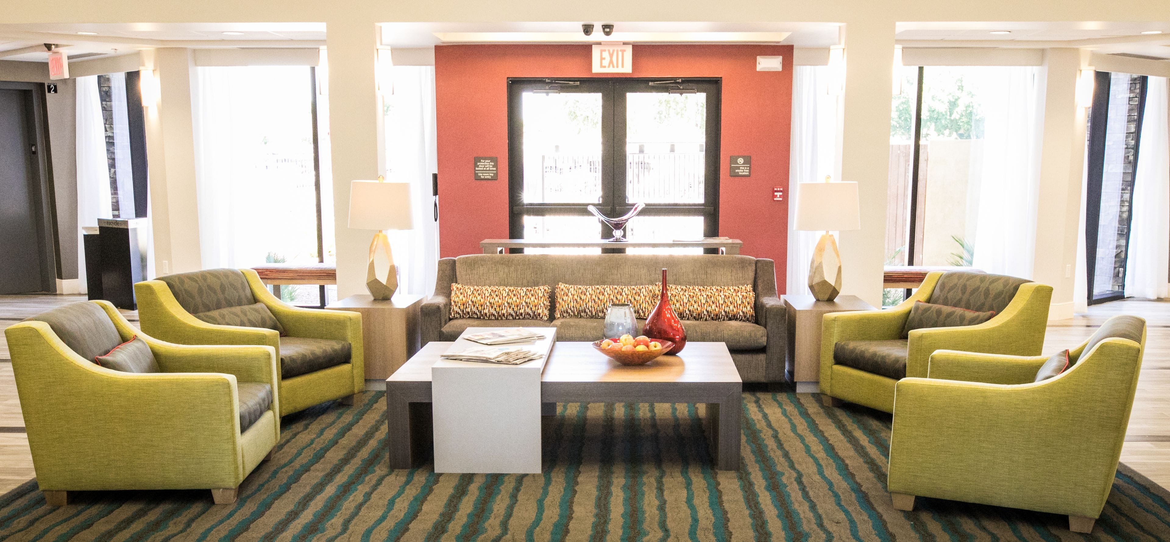 A lobby with a sofa set, a coffee table, and two armchairs.