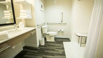 Un baño moderno con lavamanos, inodoro y zona de ducha.