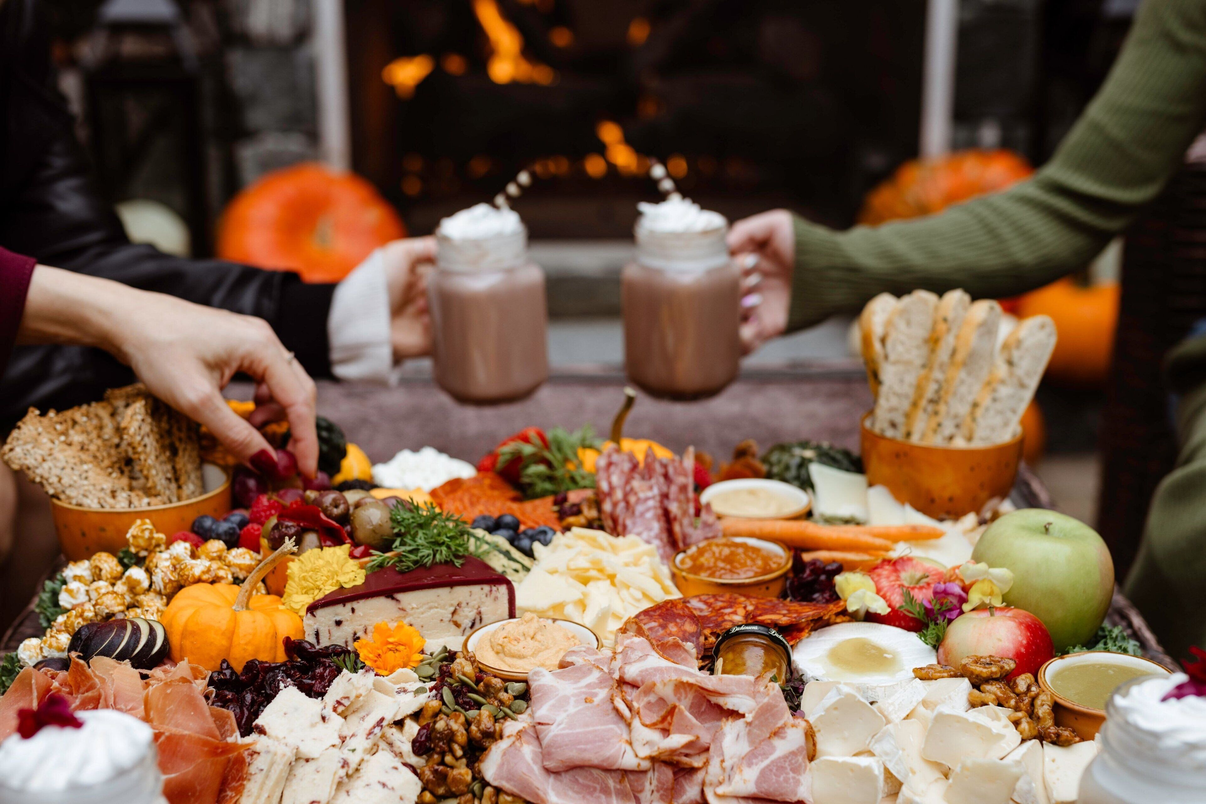 A charcuterie board with various cheeses, meats, fruits, and nuts.