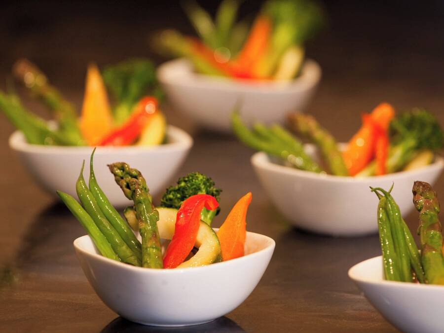 A series of white bowls containing a variety of vegetables.