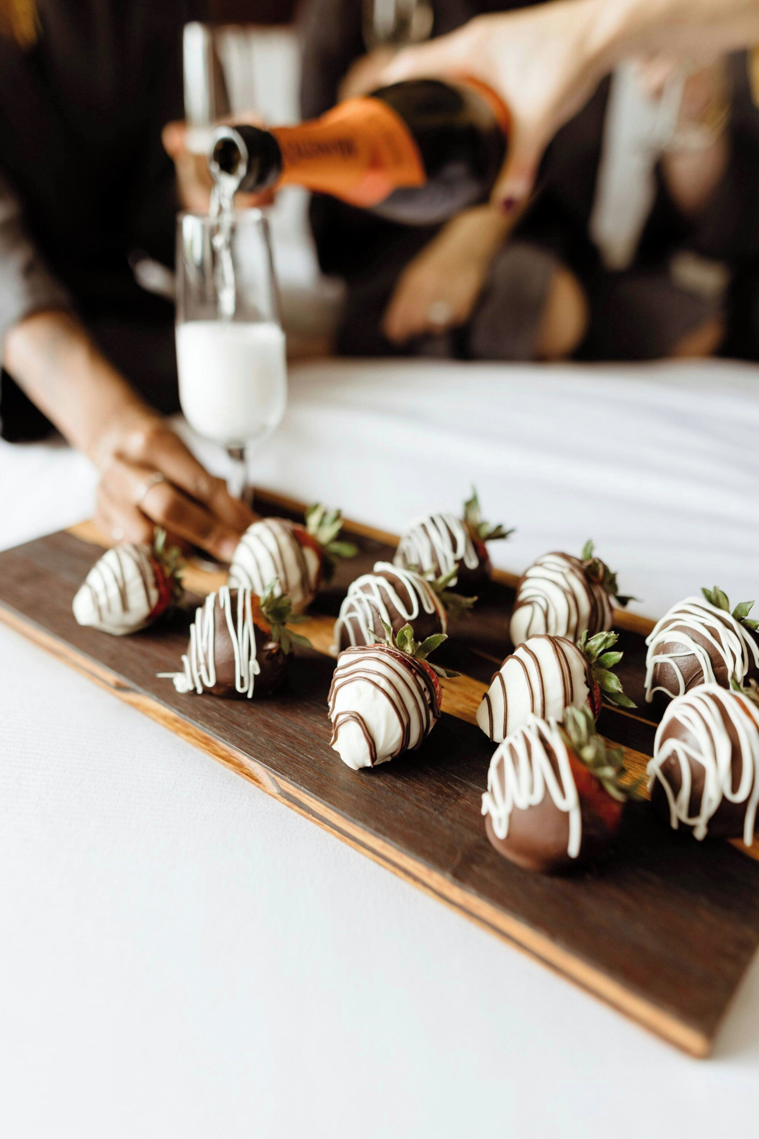 A tray of chocolate-covered strawberries on a wooden board.