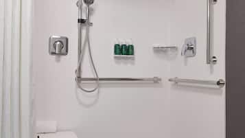A walk-in shower with a grab bar, a small sink, and a showerhead.
