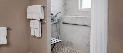 Un baño con ducha, toallero y ventana.