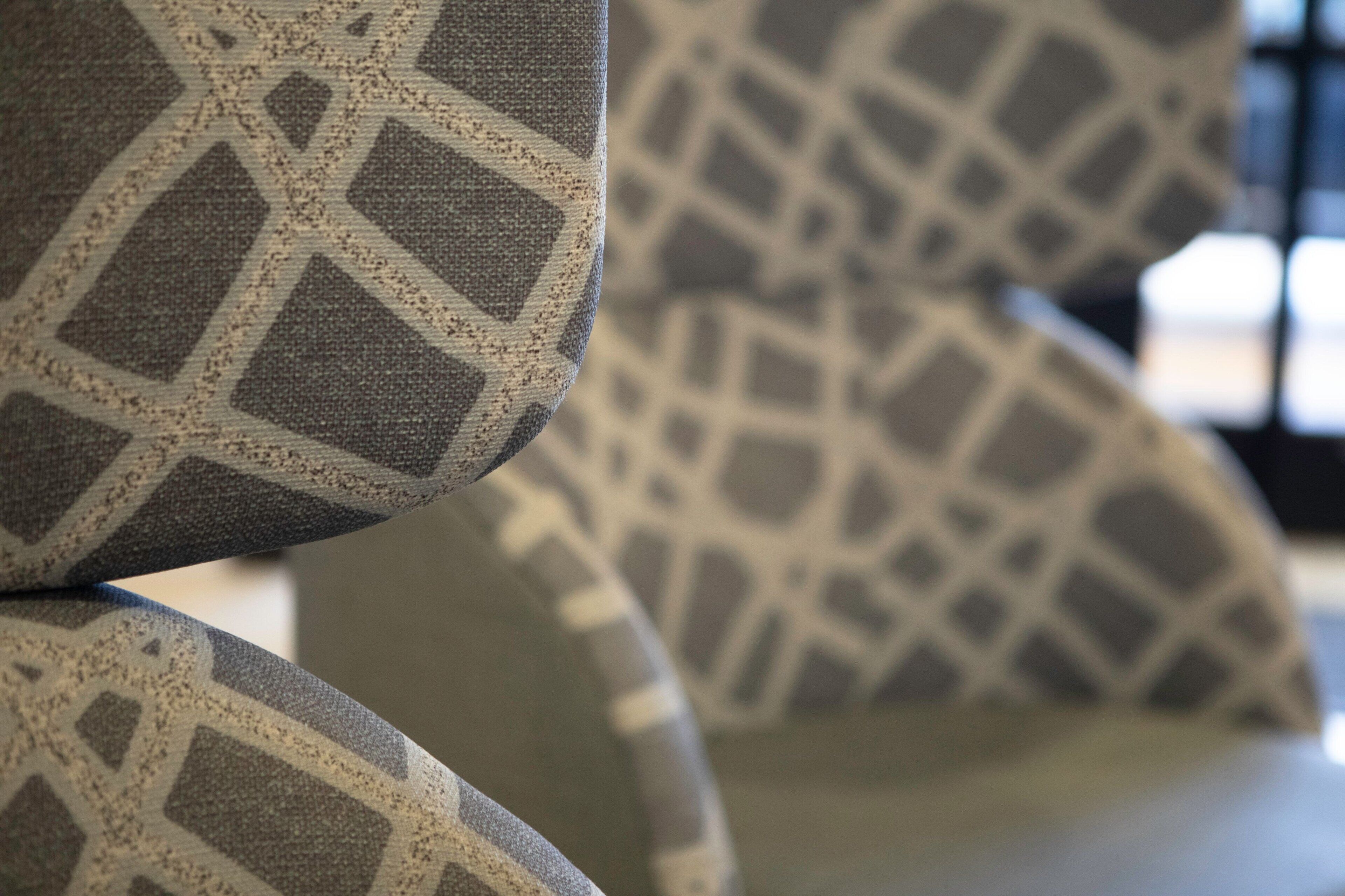 Un gros plan d’un tissu à motifs, probablement utilisé pour recouvrir un fauteuil ou un canapé.