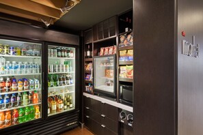 A minibar with various beverages and snacks, including bottled water, soda, and snacks.