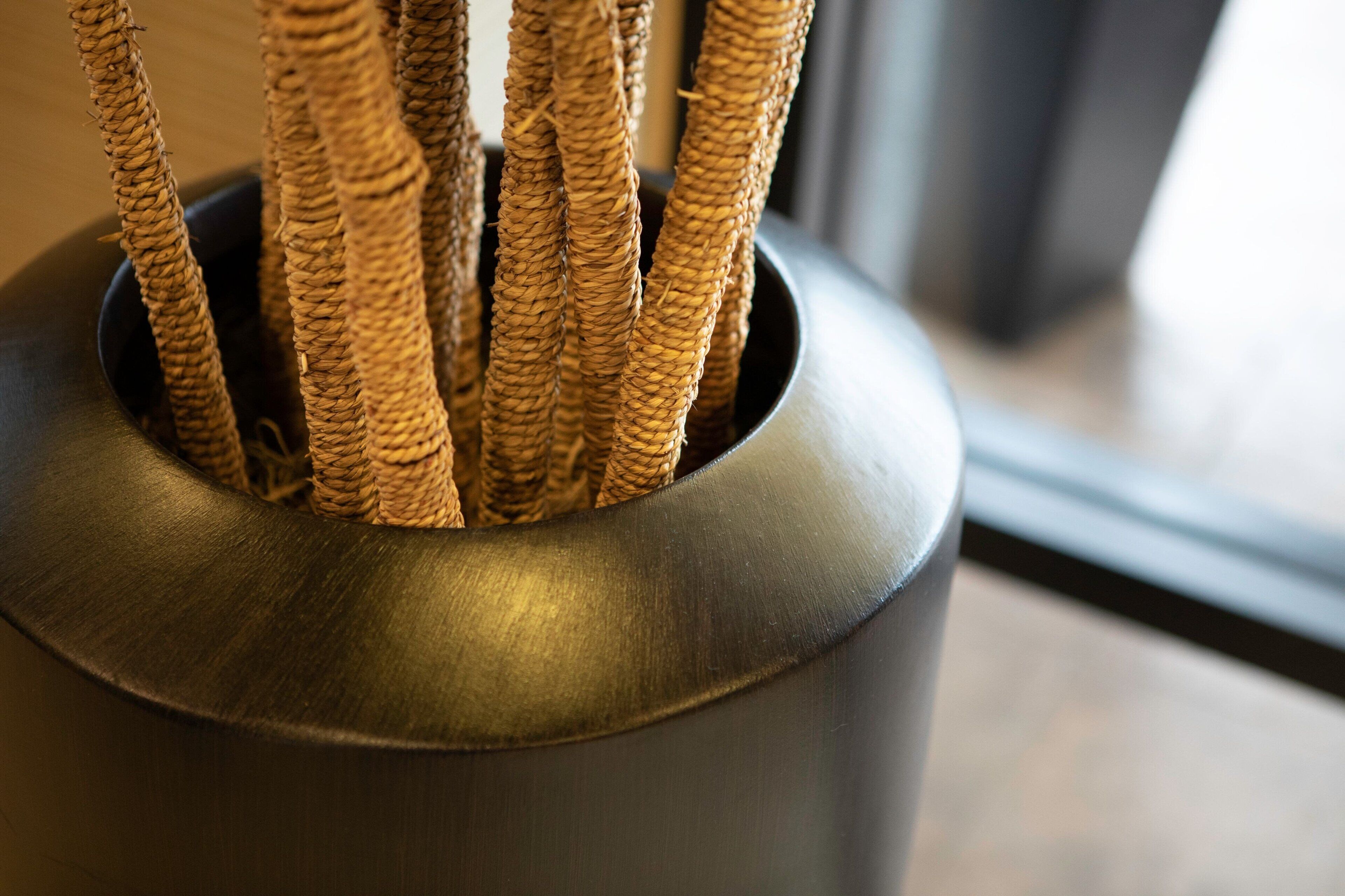 A close-up of a woven plant holder with several branches.