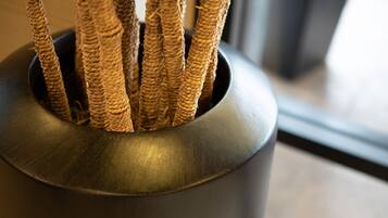 A close-up of a woven plant holder with several branches.