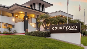 A Courtyard by Marriott hotel with a modern design, featuring a prominent entrance, a well-lit facade, and a signboard. - Courtyard by Marriott San Diego Del Mar/Solana Beach (Solana Beach)