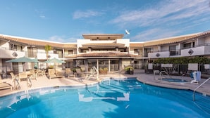 A hotel with a swimming pool, outdoor seating, and a two-story building with a tiled roof. - Courtyard by Marriott San Diego Del Mar/Solana Beach (Solana Beach)