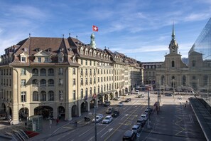 A historic building with a prominent clock tower and a large flag.