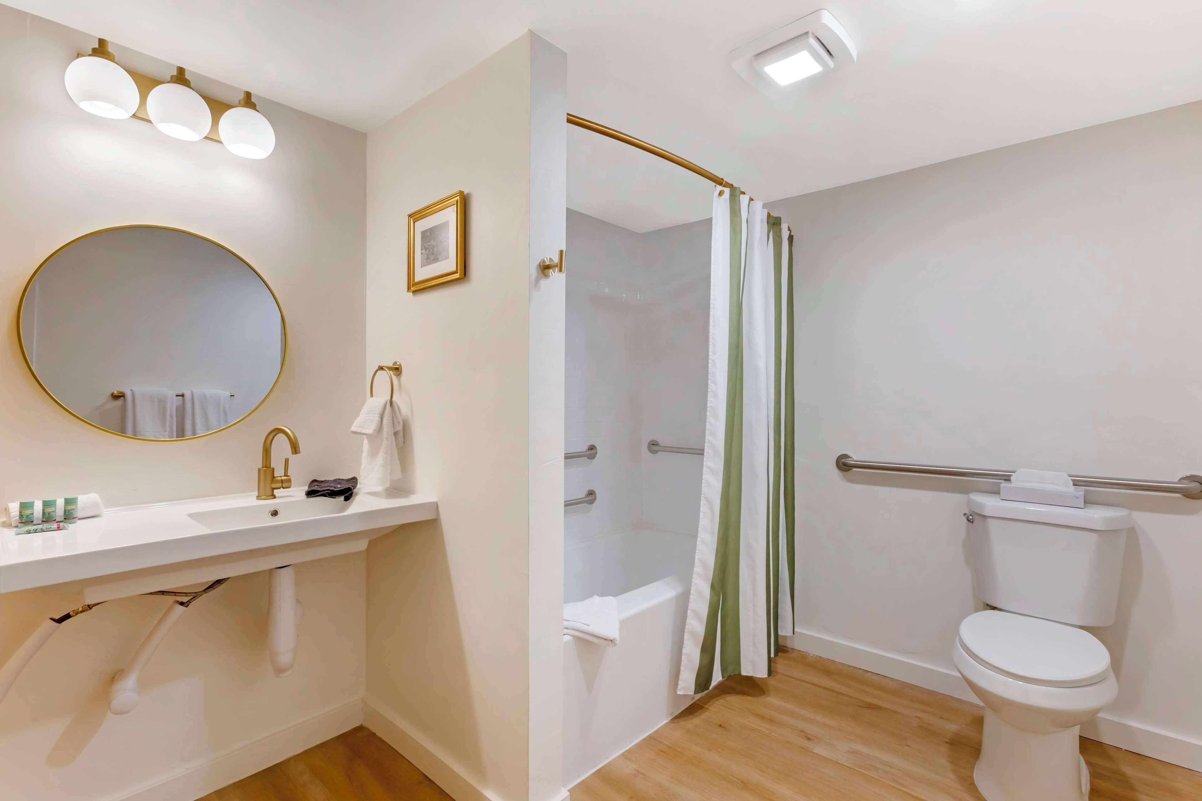 Un baño con lavabo, espejo, inodoro y zona de ducha.