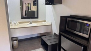 A compact bathroom with a sink, mirror, and microwave. - Motel 6 Cedar Rapids, IA (Cedar Rapids)