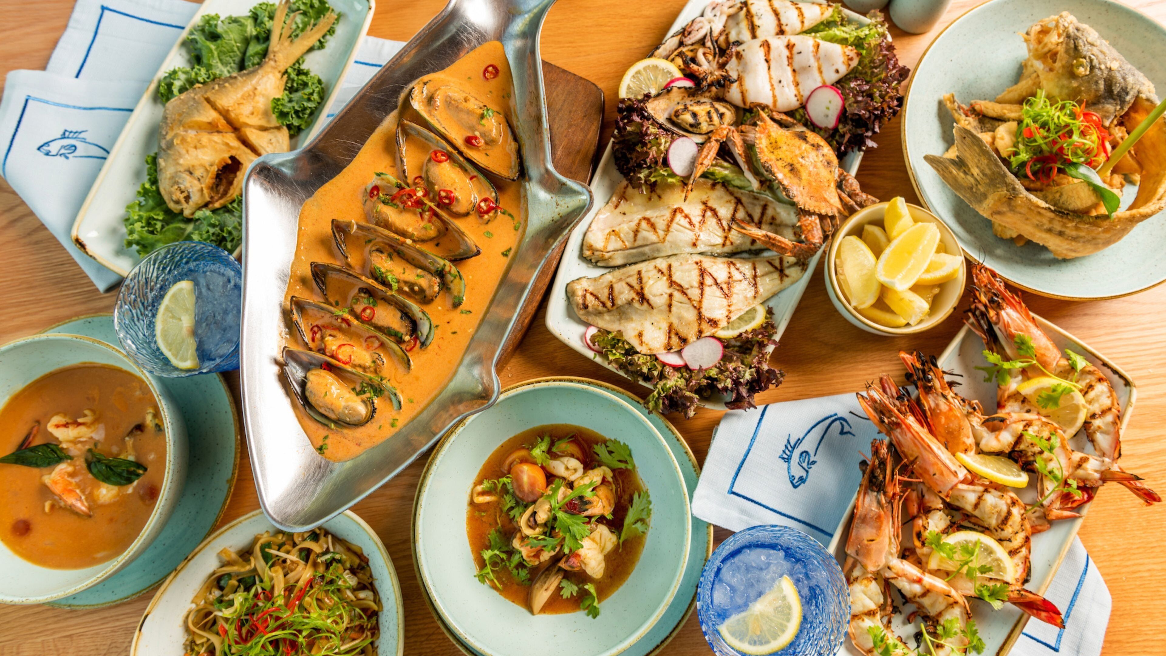 A variety of seafood dishes on a wooden table.