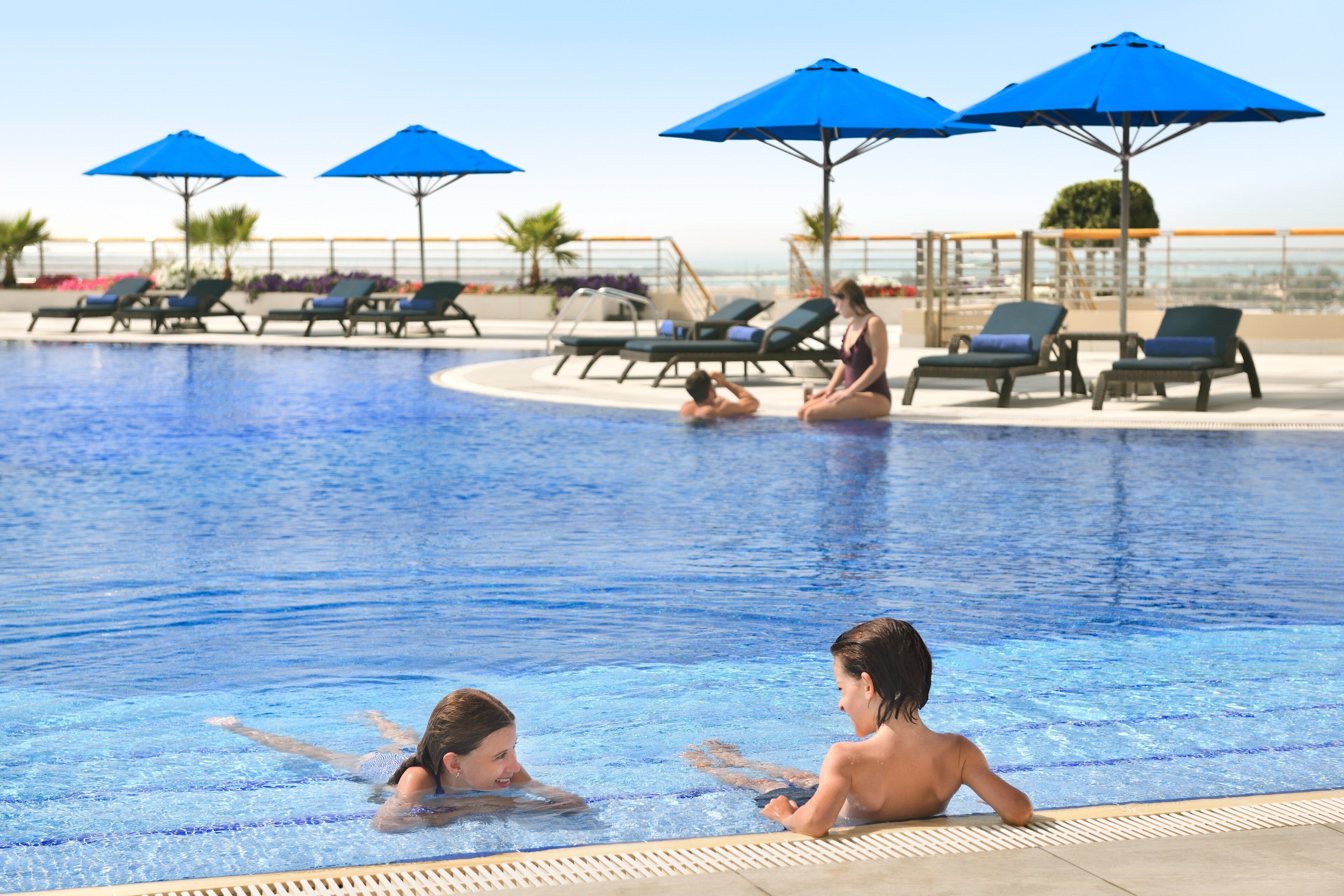 A swimming pool with lounge chairs and umbrellas.