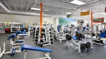 A gym with various exercise equipment, including weight benches and squat racks.