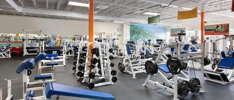A gym with various exercise equipment, including weight benches and squat racks.