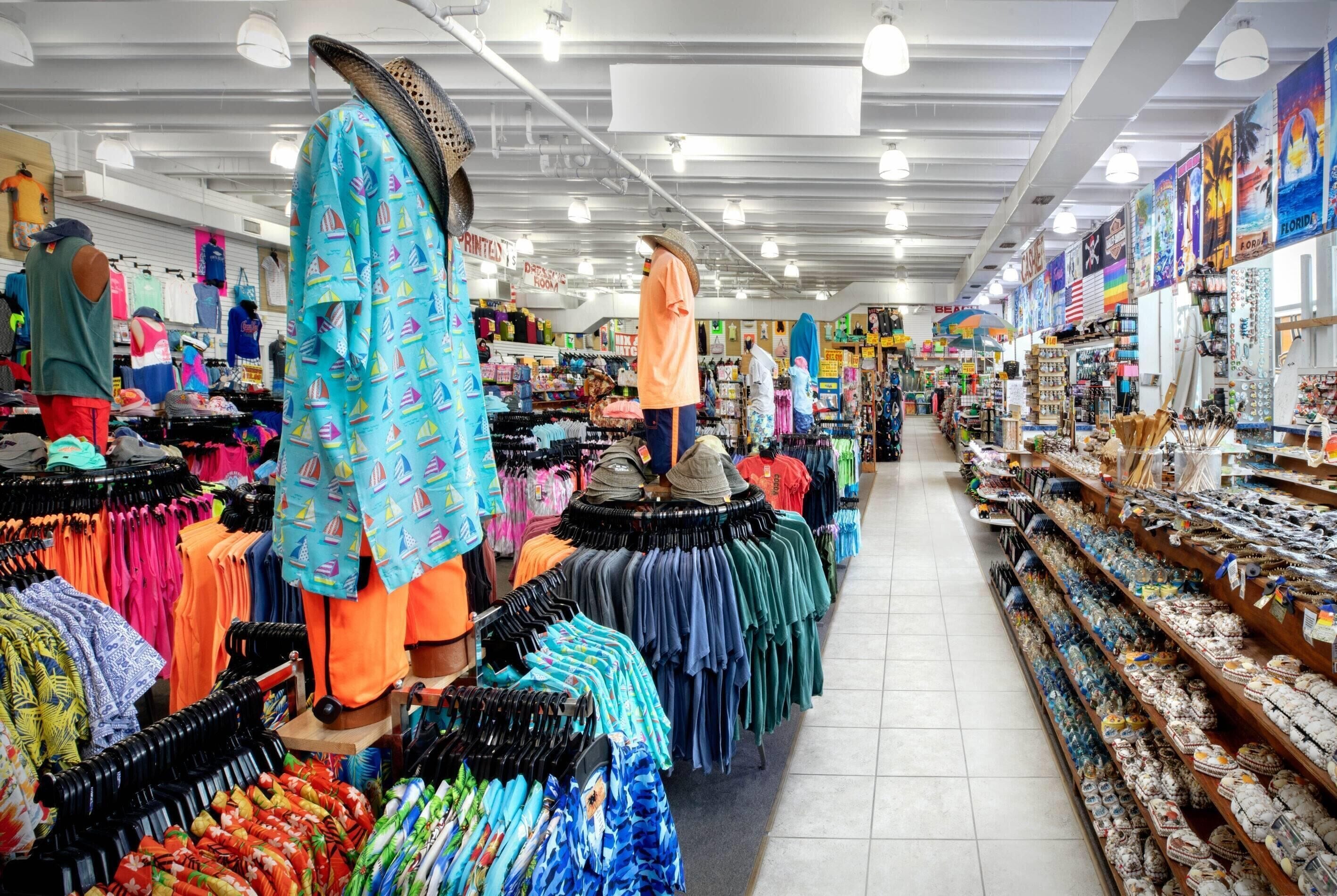 A brightly lit clothing store with racks of colorful shirts and accessories.