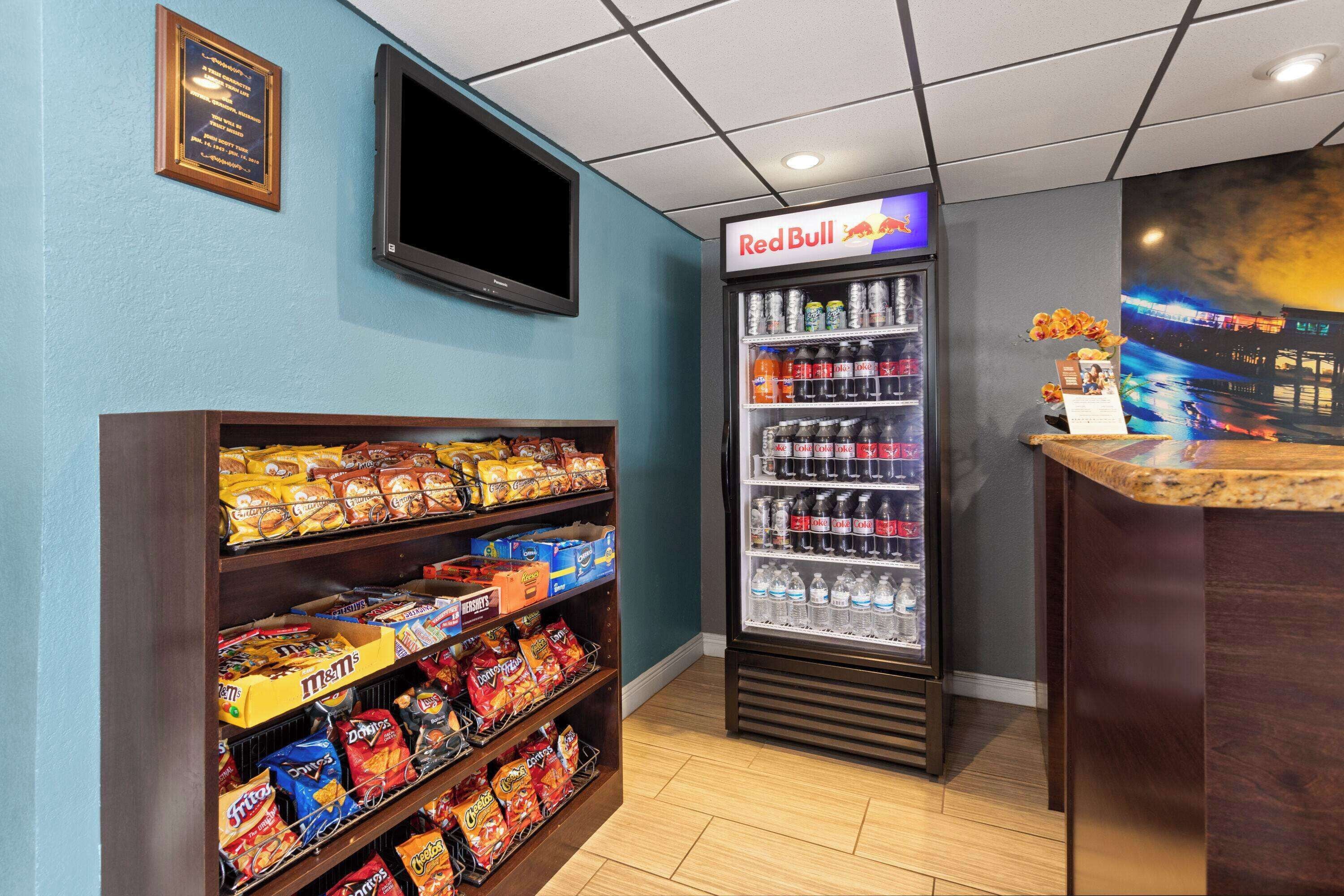 A snack bar with shelves of chips and a refrigerated drink cooler.