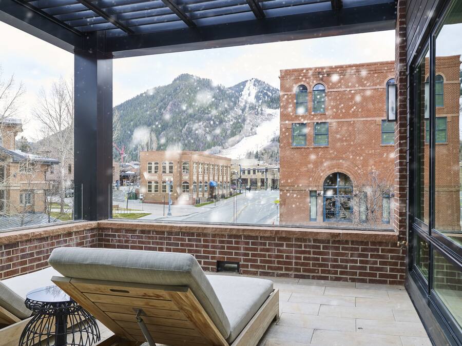 A balcony with a view of a mountain and a brick building.