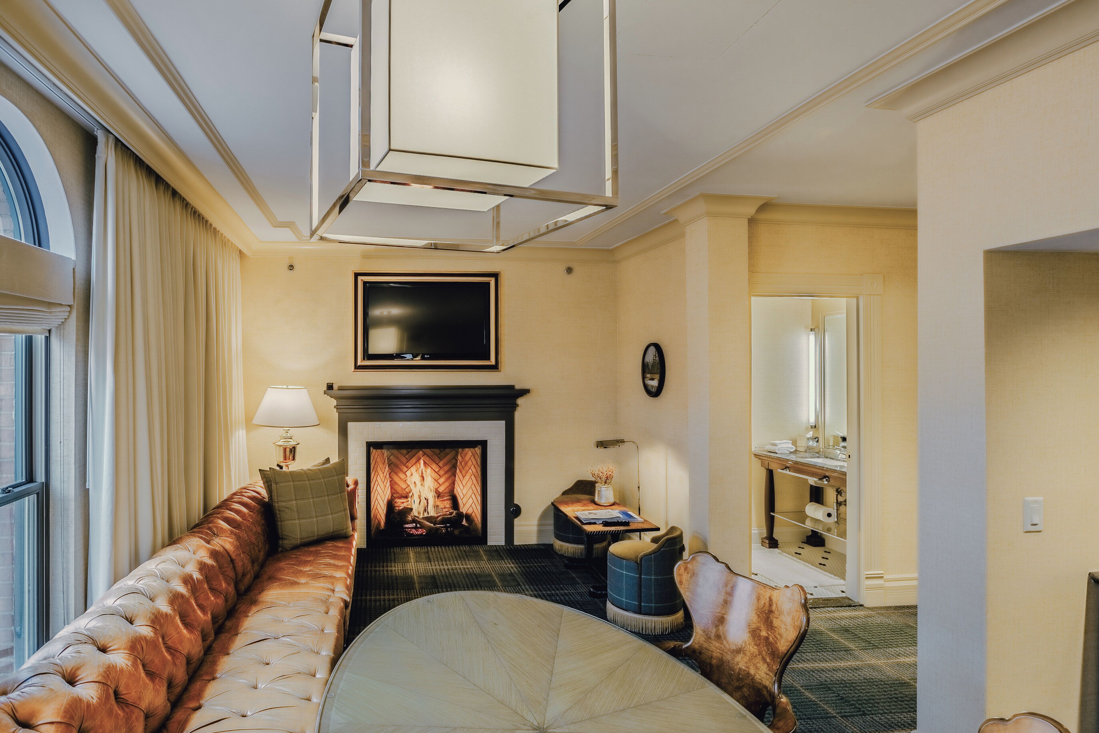 A living room with a fireplace, a sofa, a coffee table, and a television.