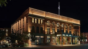 A historic brick building with arched windows and a flagpole.