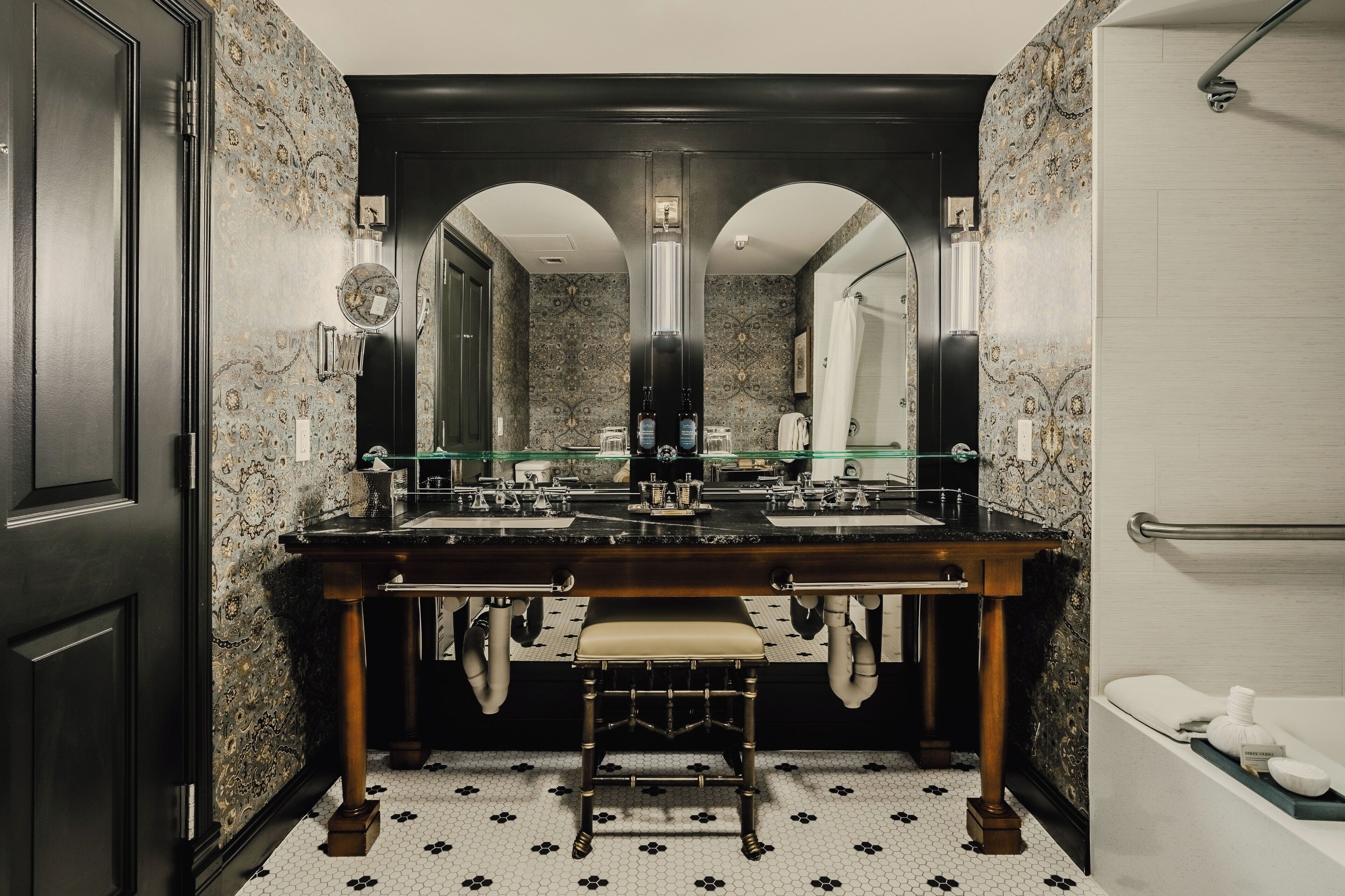 Un baño con dos lavamanos, un espejo y un banco.