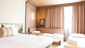 A hotel room with a large bed, a smaller bed, a sofa, and a table. - Novotel Toulouse Purpan Aéroport (Toulouse)