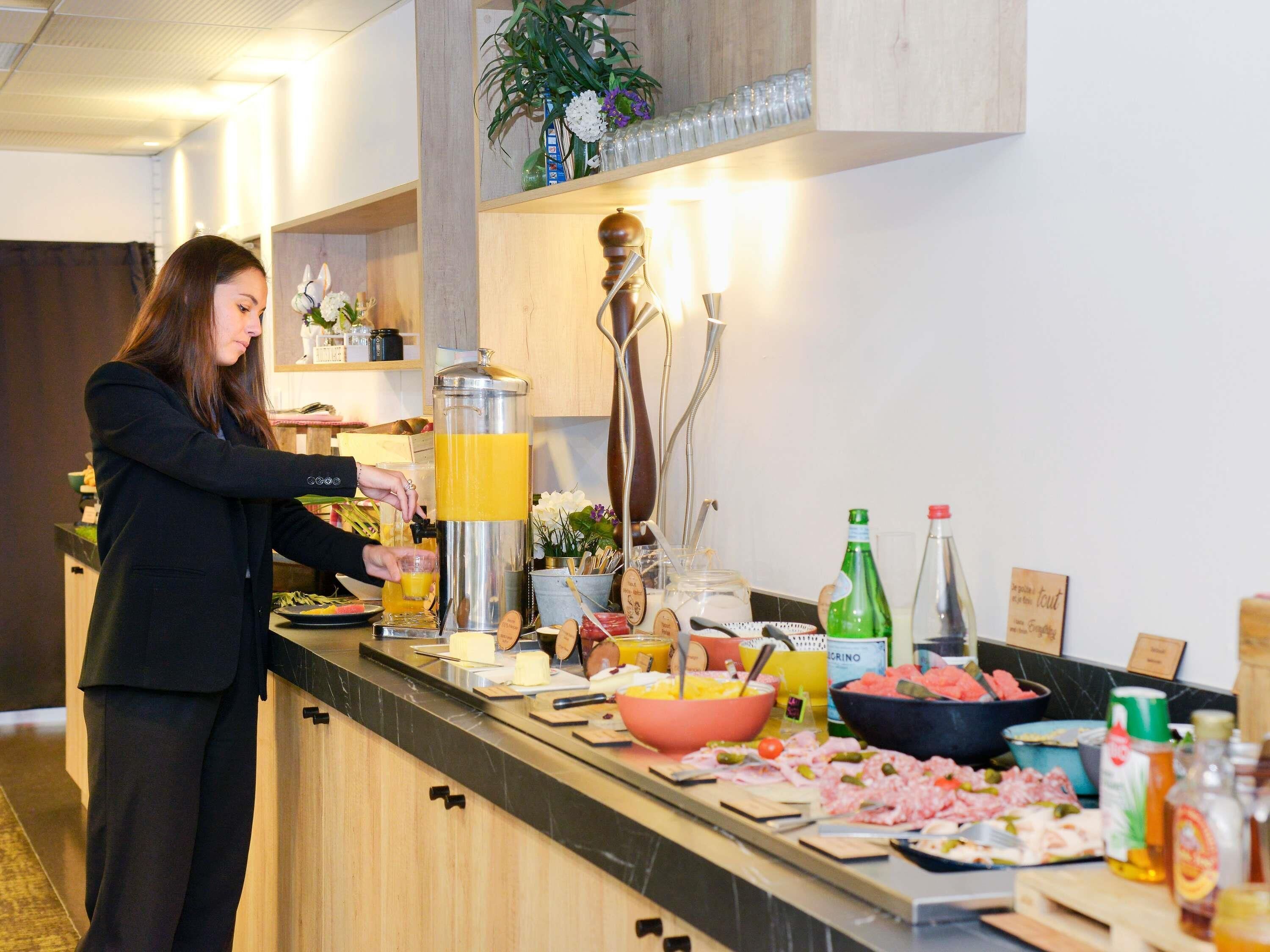 A buffet setup with a variety of food items and a juice dispenser.