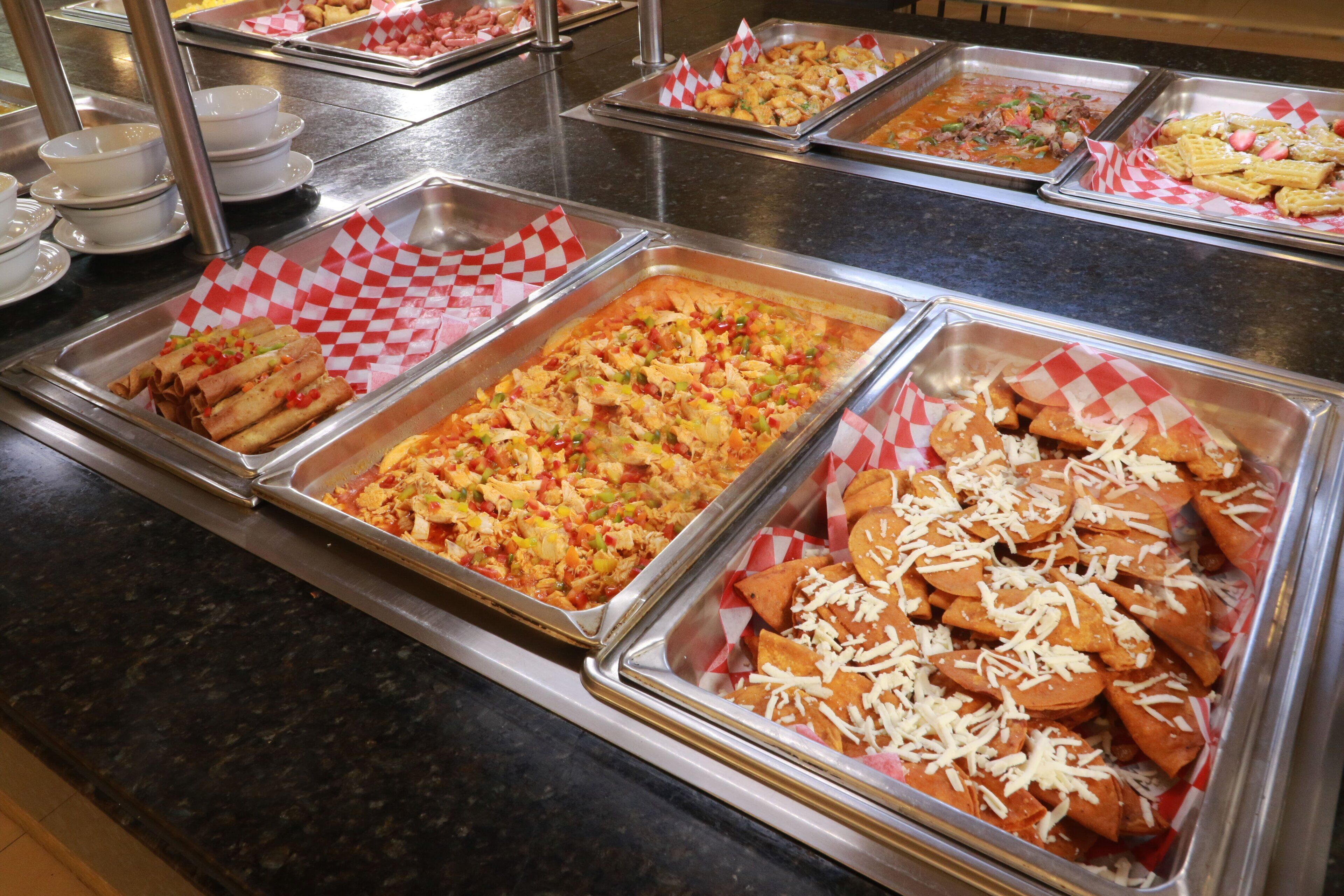 A buffet with various food options including nachos, salads, and other dishes.