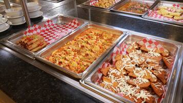 A buffet with various food options including nachos, salads, and other dishes.