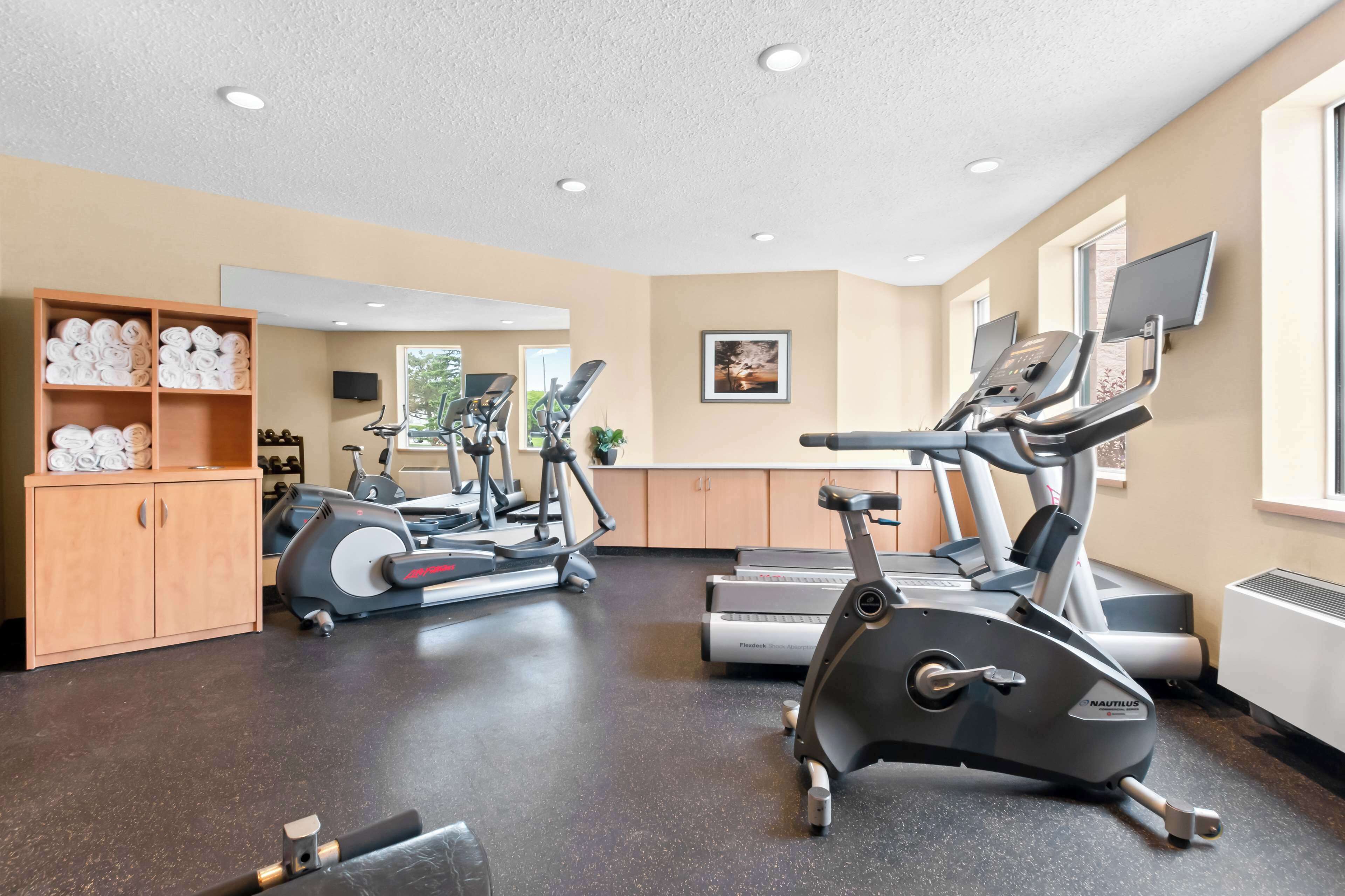 Un gimnasio con cintas de correr, bicicletas estáticas y equipo de ejercicio.