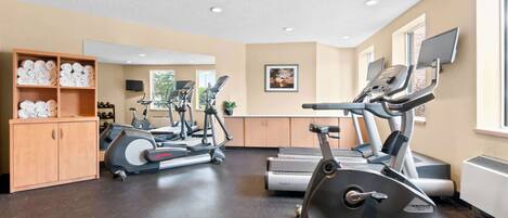 Un gimnasio con cintas de correr, bicicletas estáticas y equipo de ejercicio.