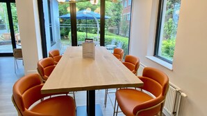 A conference room with a long table, orange chairs, and a chandelier. - The Great Barr Hotel (Birmingham)