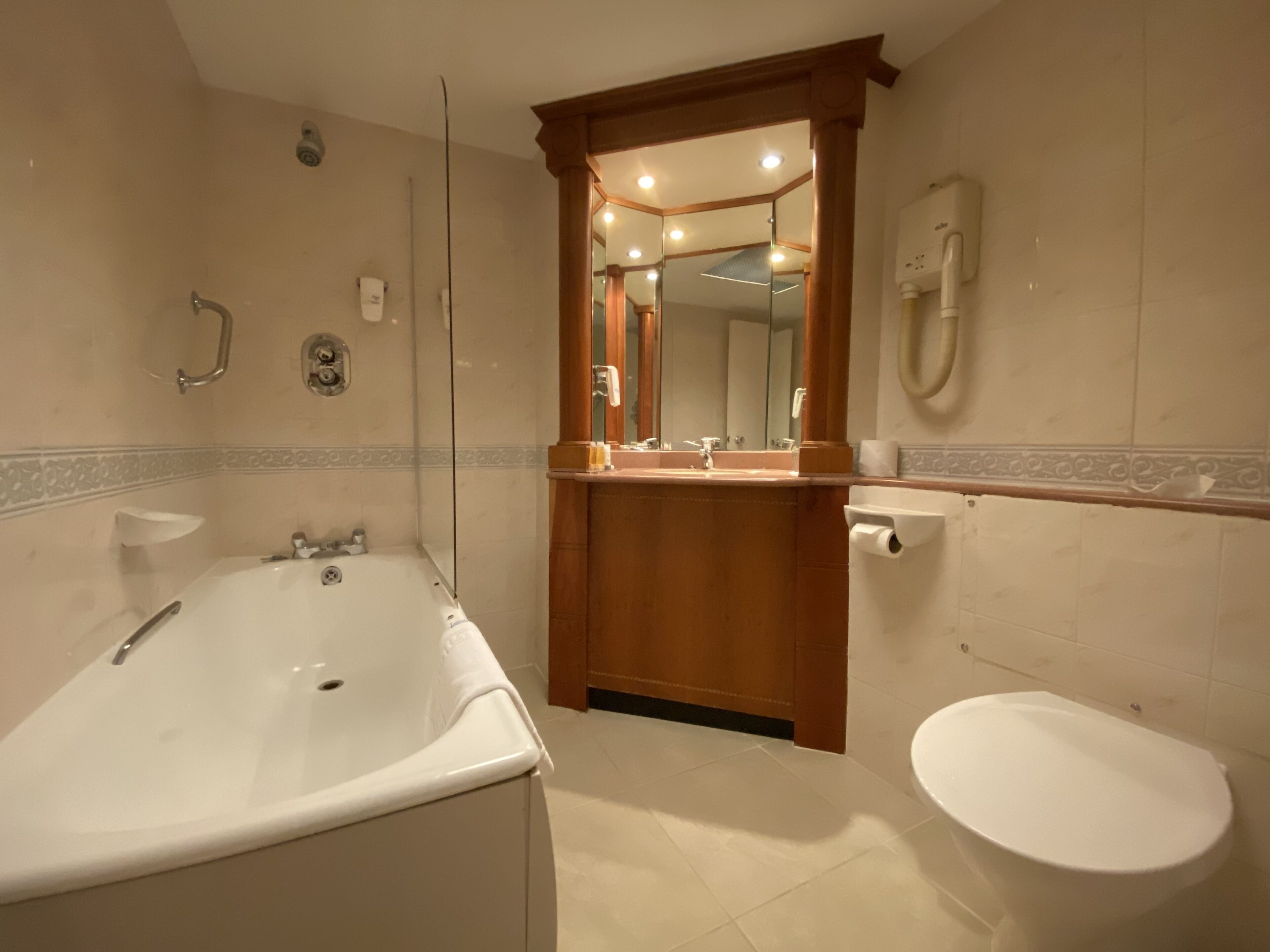 Un baño moderno con bañera, inodoro y zona de ducha.